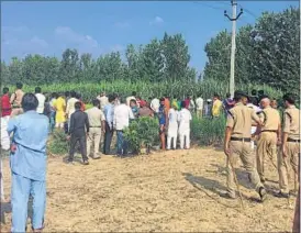  ?? HT PHOTOS ?? Villagers gather near an agricultur­al field in search of a tigress, suspected to be a man-eater, in Nainital’s Ramnagar area last week.