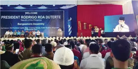  ??  ?? (Top) The Moro Islamic Liberation Front staged a massive rally in late November at its headquarte­rs in Camp Darapanan, the Philippine­s, to push for the adoption of the Bangsamoro Basic Law. (Below) Participan­ts at the rally.