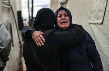  ?? Said Khatib/AFP via Getty Images ?? Palestinia­ns mourn after identifyin­g the bodies of relatives killed in an overnight Israeli bombardmen­t in the southern Gaza Strip at Al-Najjar Hospital in Rafah on Saturday.