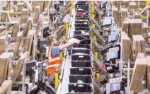  ??  ?? A man works inside Amazon Fulfilment Center in Tracy, California. — AFP