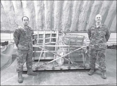  ??  ?? US Air Force men stand beside the Balangiga bells in crates at Kadena Air Base in Okinawa, Japan.