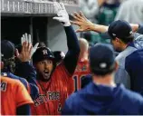  ??  ?? George Springer, left, gets hands-on after his leadoff home run against the Rangers on Friday night at Minute Maid Park.