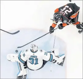  ?? REED SAXON – THE ASSOCIATED PRESS ?? Sharks goaltender Martin Jones, bottom, blocks a shot by Anaheim’s Ondrej Kase during the third period of Thursday’s Western Conference playoff game.