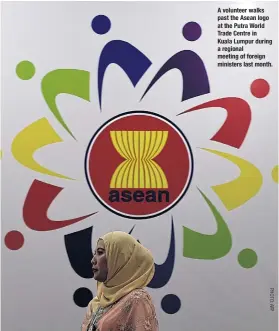  ??  ?? A volunteer walks past the Asean logo at the Putra World Trade Centre in Kuala Lumpur during a regional meeting of foreign ministers last month.