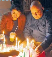  ??  ?? Familias prenden velas en el frente de las casas.