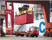  ?? BEN NELMS / BLOOMBERG FILES ?? A crane lowers a freight container onto a truck from a ship at the Port Metro Vancouver terminal. A U.S. proposal to implement a “border adjustment tax” could be disastrous for Canadian industries.