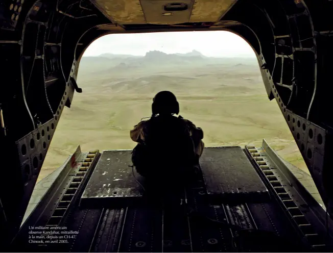  ?? © AFP/POOL/GERALD Herbert ?? Un militaire américain observe Kandahar, mitraillet­te à la main, depuis un CH-47 Chinook, en avril 2005.