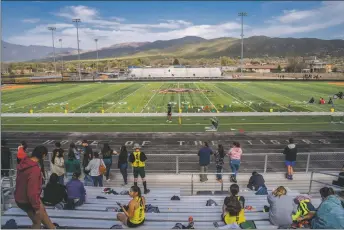  ?? NATHAN BURTON/Taos News ?? Spectators and athletes gather in the stands overlookin­g the Taos High School football field for a track and field meet on Tuesday (April 26).