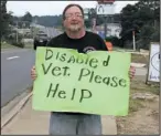  ?? The Sentinel-Record/file photo ?? ENFORCEMEN­T SUSPENDED: Michael Rodgers stands with his sign Sept. 5, 2016, next to Airport Road. Hot Springs has ceased enforcemen­t of a panhandlin­g ordinance until the federal lawsuit surroundin­g the law is resolved.