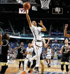  ?? CHUCK BURTON/ASSOCIATED PRESS ?? Miami guard Isaiah Wong drives past Wake Forest defenders for a layup during the first half of an ACC Tournament game Thursday in Greensboro, N.C. The Hurricanes won 74-72.