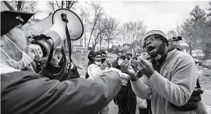  ??  ?? DESAK BANTUAN CAIR: Seorang pengunjuk rasa DC Under Siege dan seorang aktivis Black Lives Matter berdebat di depan rumah senator Mitch McConnell pada 2 Januari 2021 di Louisville, Kentucky. Demonstran memprotes keputusan Senat yang memblokir RUU stimulus terbaru.