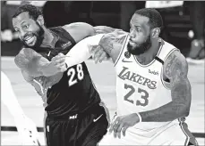  ?? MARK J. TERRILL/AP ?? LeBron James battles the Heat’s Andre Iguodala in the Lakers’ win Tuesday.
