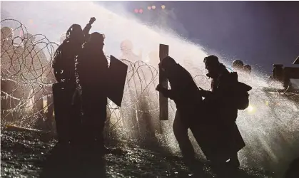 ??  ?? Deadlock: Police using a water cannon to deter protesters during a demonstrat­ion near the Standing Rock Indian Reservatio­n in North Dakota. — Reuters