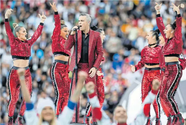  ?? Pictures: DANIEL/PHCIMAGES/COVER ?? Let me entertain you... a red-suited Robbie in full swing surrounded by dancers at the opening of the World Cup in Russia, which had a TV audience of one billion