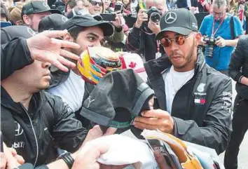  ?? AP ?? Mercedes’ Lewis Hamilton signs autographs for fans at the Canadian Grand Prix on Thursday in Montreal.