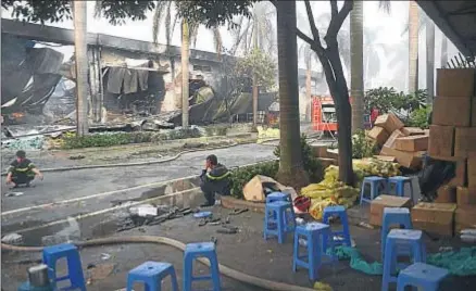  ?? THANH TUNG TRUONG / REUTERS ?? Dos bomberos descansan junto a una fábrica de zapatos incendiada en la provincia de Binh Duong