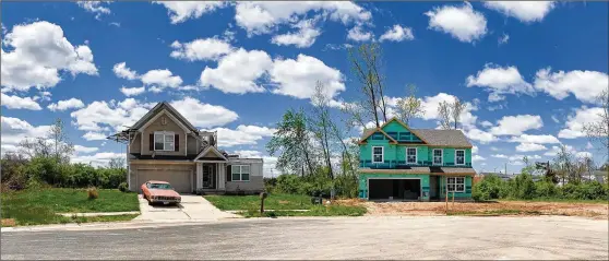  ?? CHRIS STEWART PHOTOS / STAFF ?? A new house at right is being built on Galilieo Avenue cul-de-sac in Trotwood next to a house abandoned and unchanged since last May’s Memorial Day tornadoes. In Trotwood, 203 structures were left unlivable after the tornado, according to Montgomery County records.