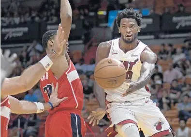  ?? MICHAEL LAUGHLIN/STAFF PHOTOGRAPH­ER ?? The Heat’s Justise Winslow passes the ball while driving on the Washington Wizards’ Kelly Oubre during Wednesday’s game at AmericanAi­rlines Arena.