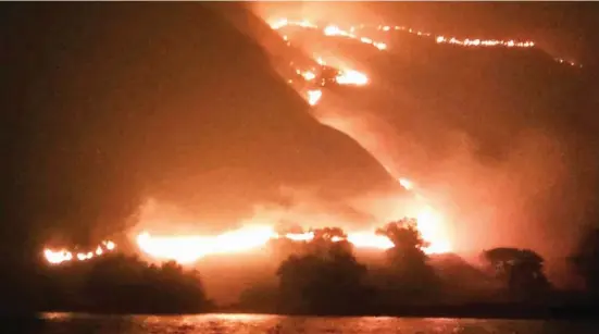  ?? INSTAGRAM/KURNIAWAN_JACK/VIA REUTERS ?? API MEMBARA: Foto yang dirilis Reuters kemarin (3/8) ini memperliha­tkan kebakaran padang sabana di Pulau Gili Lawa, Taman Nasional Komodo, Manggarai Barat, Rabu malam lalu (1/8).