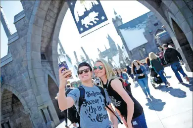  ?? REUTERS ?? Guests pose before they enter Hogsmeade Village during a tour of The Wizarding World of Harry Potter theme park at Universal Studios in Los Angeles, California.