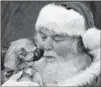  ??  ?? Santa Steve Stickley holds Edward, a mixed-breed, earlier this month near Winchester, Va. SCOTT MASON / WINCHESTER STAR / AP