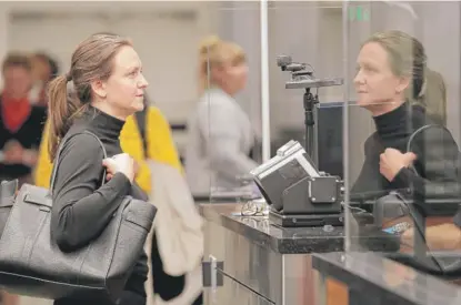  ??  ?? Katrina Poulsen, a visitor from Denmark, stands in front of a face recognitio­n camera at Orlando Internatio­nal Airport on Thursday.