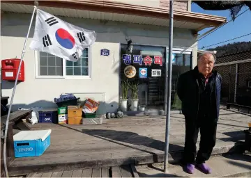  ??  ?? KIM IK-SOO, the owner of a small supermarke­t, is seen in front his shop in the South Korean border village of Goseong last week. Kim said buses carrying up to 3,000 tourists a day used to pass by before the tours ended, enabling his business to thrive....