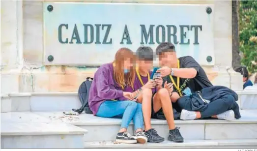 ?? JULIO GONZÁLEZ. ?? Adolescent­es mirando el móvil esta primavera en Cádiz.