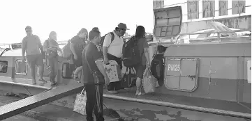  ??  ?? Passengers step into an express boat at the Sibu terminal.