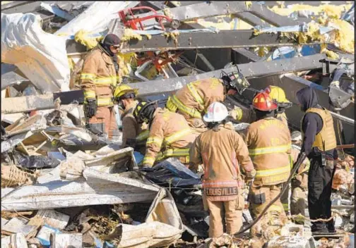  ?? ?? Emergency workers search through what is left of the Mayfield Consumer Products Candle Factory after it was destroyed by a tornado in Mayfield, Ky., Saturday night. Now, authoritie­s are examining claims that bosses threatened to fire workers if they left early.