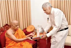  ??  ?? The picture shows Prime Minister Ranil Wickremesi­nghe offering Pirikara to the Mahanayake of the Asigiriya Chapter the Most Venerable Warakagoda Gnanaratan­a Thera.