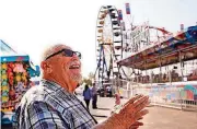  ?? [PHOTO BY JIM BECKEL, THE OKLAHOMAN] ?? Frank Zaitshik, 71, laughs Wednesday while recalling his many years in the carnival business. Zaitshik, owner of Wade Shows, started in 1966 as a teen working in a game booth on the midway. Crews spent most of Wednesday putting finishing touches on...