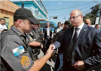  ?? Philippe Lima - 13.ago.19/GOVRJ ?? O governador Wilson Witzel (PSC) cumpriment­a policiais em Japeri (RJ)