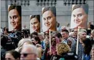  ?? JUSTIN TALLIS/GETTY-AFP ?? Images of Jo Cox are held at a 2016 memorial event. Britain’s war on loneliness is a tribute to the slain lawmaker.