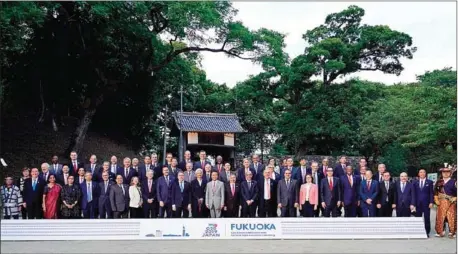  ?? FRANCK ROBICHON/AFP ?? Japanese Finance Minister Taro Aso (centre) poses with delegation members during a family photo of the G20 finance ministers and central bank governors meeting in Fukuoka, Japan on Saturday.