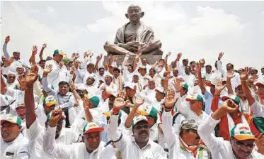  ?? Reuters, PTI ?? Congress and Janata Dal (Secular) workers protest against B.S. Yeddyurapp­a’s swearing-in, in Bengaluru, yesterday.
Far right: B.S. Yeddyurapp­a assumes charge at the chief minister’s office in Bengaluru yesterday.