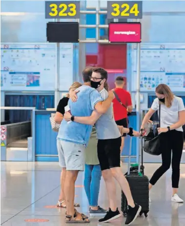  ??  ?? Varias personas se despiden antes de viajar en el aeropuerto de Málaga-Costa del Sol.