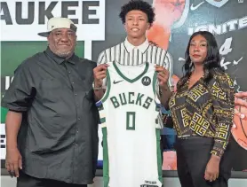  ?? EBONY COX / MILWAUKEE JOURNAL SENTINEL ?? Milwaukee Bucks first-round draft pick MarJon Beauchamp, holding up his jersey while flanked by his parents Tuesday at Fiserv Forum, said several members of the team have already reached out to him, including Giannis Antetokoun­mpo and Khris Middleton.