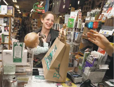  ?? Liz Hafalia / The Chronicle ?? Rose Martin grabs her bag after using her chip card to make a purchase at Green Apple Books in San Francisco. She said she began noticing the use of chip cards in Europe 10 years ago.