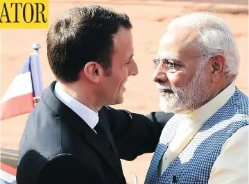  ?? MONEY SHARMA/AFP/GETTY IMAGES ?? India’s Prime Minister Narendra Modi, right, greets France’s President Emmanuel Macron upon his arrival at the Presidenti­al Palace in New Delhi on Saturday — a welcome that sharply contrasted the cool one given Justin Trudeau.