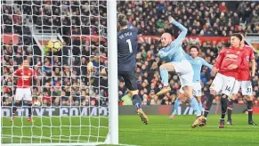  ??  ?? MICHAEL REGAN/GETTY IMAGES David Silva hooks home Manchester City’s first goal against Manchester United past David De Gea in City’s 2-1 victory at Old Trafford on December 10, 2017.