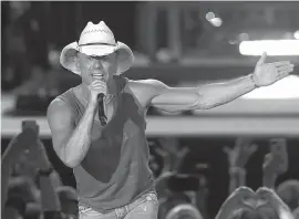  ?? Associated Press ?? ■ Kenny Chesney performs during the Trip Around the Sun Tour in Phoenix. After Hurricane Irma decimated the U.S. Virgin Islands last year, Chesney started writing songs and organizing relief efforts. Chesney is donating proceeds from the sale of his new album, “Songs for the Saints,” to a foundation he set up to support recovery on the islands.