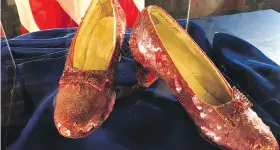  ?? AP ?? A pair of ruby slippers once worn by actor Judy Garland in the The Wizard of Oz are displayed at a news conference Tuesday. The FBI said the slippers, stolen in 2005 from the Judy Garland Museum in Michigan, were recovered in a sting operation.