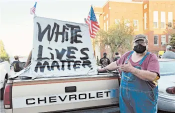  ?? CLAIRE GALOFARO/AP ?? Michael Johnson was part of a group that believed antifa was coming to Leitchfiel­d, Kentucky, when a resident organized a Black Lives Matter rally. He said the sign on his truck was meant to say that all people’s lives should matter equally.