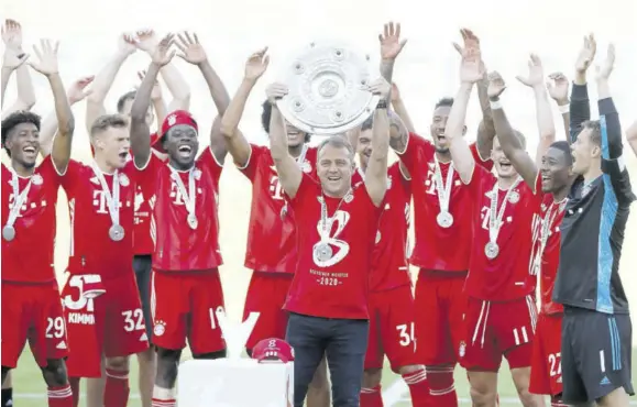  ?? (Photo: AP) ?? Munich’s Head Coach Hansi Flick lifts the trophy after the German Bundesliga soccer match between VFL Wolfsburg and FC Bayern Munich in Wolfsburg, Germany, Saturday, June 27, 2020. Bayern won the eighth-straight Bundesliga title.