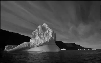  ??  ?? An iceberg floats in 2011 near Qeqertarsu­aq, Disko Island, Greenland. Global warming is shifting the way the Earth wobbles on its polar axis, a new NASA study finds. Melting ice sheets, especially in Greenland, are changing the distributi­on of weight...