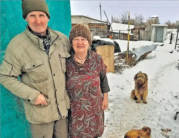  ?? EL PAÍS ?? Realidad. Gregori y Liudmila Vovk, junto al módulo en el que viven en el municipio de Zagaltsi. Detrás, cubierto de nieve, lo que queda de su casa.