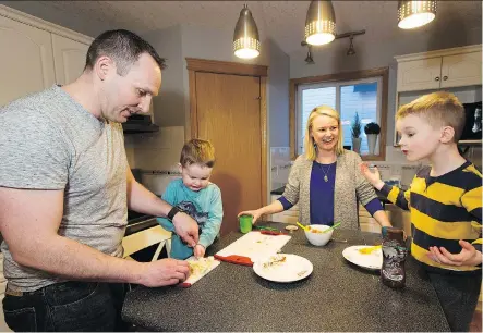  ?? GREG SOUTHAM ?? Bekki Hall with husband Doug and sons Riley, left, and Griffin prepare dinner at home earlier this month in St. Albert. Bekki tried HelloFresh meal kits for a week, but found the service to be too expensive to continue. She also says it did not save the family any time on food preparatio­n.