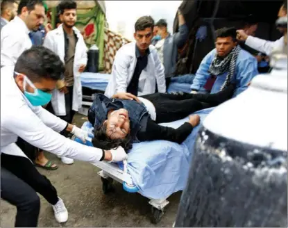  ?? ALAA AL-MARJANI / REUTERS ?? A medical crew carries a wounded man during ongoing protests in Najaf, Iraq, on Dec 1.