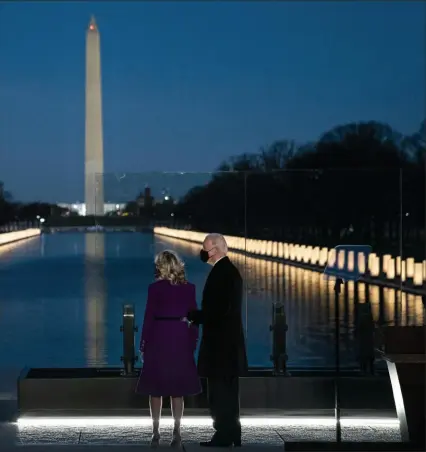  ?? Doug Mills/The New York Times ?? Jill Biden and President-elect Joe Biden stand at the Lincoln Memorial Reflecting Pool on Tuesday evening during a COVID-19 memorial event in Washington.